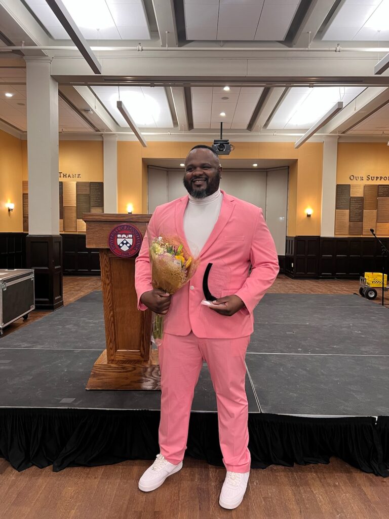 Felix Shondell Jones, wearing a pink suit, accepts the Dr. Judith Rodin Community Education Award.