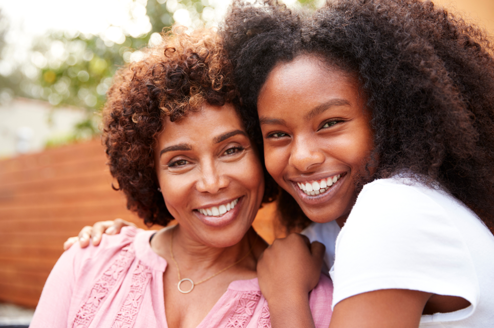 mother and daughter hugging and smiling together