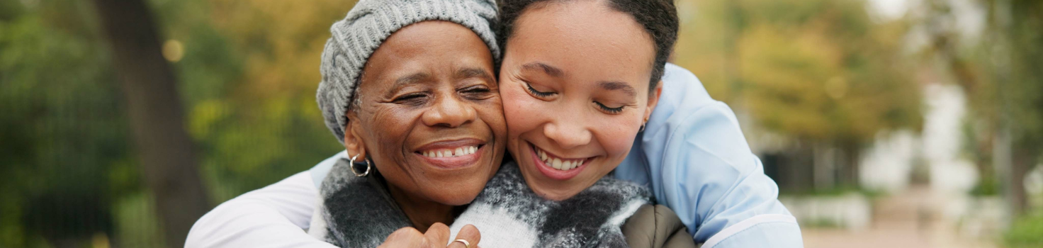 Two Black people hugging and enjoying the outdoors